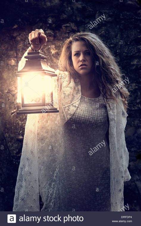 Woman holding lantern in the dark Stock Photo: 66108284 - Alamy Carrying Lantern Reference, Holding A Lamp Reference, Woman Holding Something Pose, Holding Lantern Pose Reference Drawing, Woman Casting Spell Pose, Holding Lantern Pose Reference, Someone Holding A Lantern, Hand Holding Lantern Reference, Holding Hand Out Pose Reference