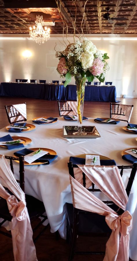 Navy Blue Crushed Taffeta Linens on Headtable Blush Chair sashes Navy Blue Napkins Gold chargers White linens for guest tables  Blush Uplights Navy Blue And Rose Gold Dinner Table, Rose Gold Navy Blue And White Wedding Theme, Navy Blue And Rose Gold And Black Wedding, Pink And Navy Table Setting, Navy Blue And Rose Gold Decorations, Navy And Pink Birthday Party, Navy Blue And Pink Centerpieces, Navy Blue Blush Pink Rose Gold Wedding Decor, Navy And Blush Table Setting