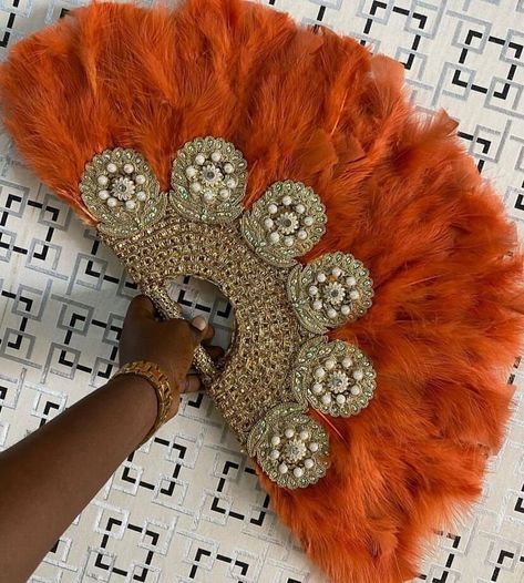 Orange Gold Feather Hand Fan, Clutch Semi-Circle African Traditional Wedding Bridal Hand Fan, Nigerian Wedding Hand fan  NEED OTHER DESIGNS AND COLOURS OF HAND FANS, BRAIDED WIGS, AUTOGELE HEADWRAPS AND AFRICAN CORAL BEADS, VISIT OUR ETSY SHOP HERE: https://sereneafrica.etsy.com This beautifully crafted African bridal accessory adds spice to your outfit on your wedding day. It can also be used by guests at a wedding. Production/ processing time is 1 week. We use DHL Express, it takes 3-5 busines African Hand Fans, African Wedding Headwrap, Nigerian Feather Fan, Bridal Handfan Nigeria, Orange Traditional Dresses African, Nigerian Fans For Wedding, Feather Fans Wedding, African Feather Fan, Nigerian Hand Fan