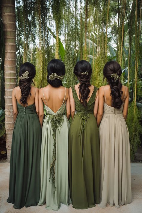 Four women in elegant mixed green bridesmaid dresses stand with their backs to the camera. Their hair is styled in braided updos with floral accents, and they are surrounded by lush greenery, creating a serene, natural setting. Green Shades Dress, Forest Themed Bridesmaid Dresses, Wedding Olive Green Color Schemes, Green Bridesmaid Dresses Palette, Different Bridesmaid Dresses Mix Match Color Palettes, Peacock Green Bridesmaid Dresses, Shades Of Wine Bridesmaid Dresses, Sage Green And Burgundy Bridesmaid Dresses, Different Shade Green Bridesmaid Dresses