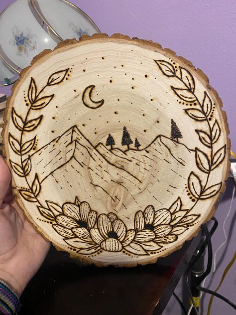 This is a pretty picture of some mountains with a flower border. It's a simple picture, but will be a great addition to any room. Completely hand burned! Woodburning Ideas Design, Western Wood Burning Ideas, Pirogravura Ideas, Easy Wood Burning Ideas, Cabin Projects, Burning Mountain, Bleach Shirt Diy, Bleach Shirt, Woodburning Projects