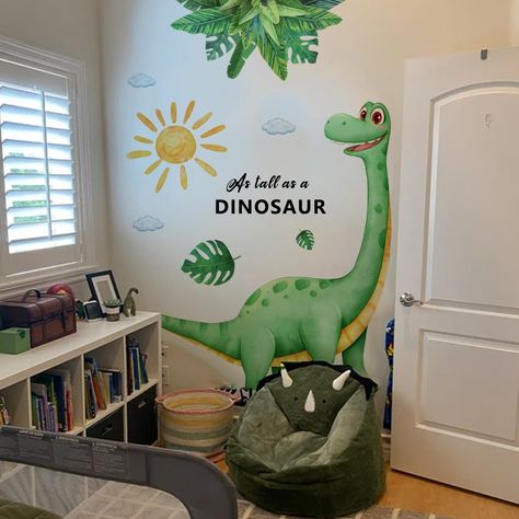 PRICES MAY VARY. Vibrant Dinosaur Wall Decals: Liven up any room with these eye-catching wall stickers featuring a large dinosaur, sun, clouds and tropical leaf patterns. Versatile Decor: Perfect for kids' bedroom, nursery, playroom, classroom, or any space in need of a fun, prehistoric touch Easy Application: Peel-and-stick design allows for quick and hassle-free installation on any smooth, flat surface. Removable and Reusable: Made from high-quality PVC material, these decals can be reposition Bedroom Plant Wall, Kindergarten Decorations Wall, Dinosaur Toddler Room, Toddler Daycare Rooms, Nursery Daycare, Boys Dinosaur Bedroom, Stickers For Boys, Dinosaur Kids Room, Boys Room Wallpaper