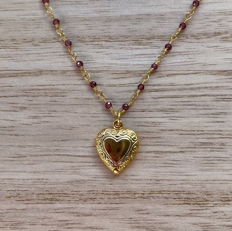 This dainty necklace is handcrafted using a 2mm authentic garnet wire-wrapped chain and a 11mm heart pendant. *Please note that the pendant does not have a garnet stone.* The chain and pendant are 24k gold plated.  This necklace is hypoallergenic. (Cadium free, lead free, and nickel safe) Garnet is an energizing stone that promotes passion and love.  The necklace comes in a ribbon-wrapped box, ready to be gifted. If you would like to leave a note for the recipient, you can do so during checkout. Gold Cameo Necklace, Jewelry Making Gold, Gold Garnet Jewelry, 90s Inspired Jewelry, Gold Red Heart Necklace, Vintage Necklace Gold, Cool Gold Necklaces, Vintage Necklace Pendant, Red And Gold Jewelry Aesthetic