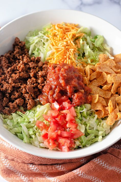 This Fritos Taco Salad is a perfect family meal! Fresh lettuce, tomato, and onion combined with seasoned ground beef, cheese, and Fritos corn chips, then tossed with dressing and salsa for a delicious and super easy to make taco salad. #tacosalad #salad #tacos #dinnerrecipe #fritos Fritos Taco Salad, Fritos Salad, Frito Taco Salad, Frito Recipe, Blt Salad Recipe, Frito Corn Salad, Taco Salad Doritos, Chili Cheese Fritos, Fritos Corn Chips