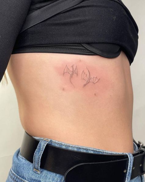 Fine line dragons tattooed on the rib. Back Tattoo Dainty Women, Tiny Delicate Tattoos, Tiny Dragon Tattoo For Women, Rib Tattoo Stencil, Lion Dragon Tattoo, Dragon Tattoo Minimal, Minimal Dragon Tattoo, Dragon Rib Tattoo, Dainty Rib Tattoos For Women