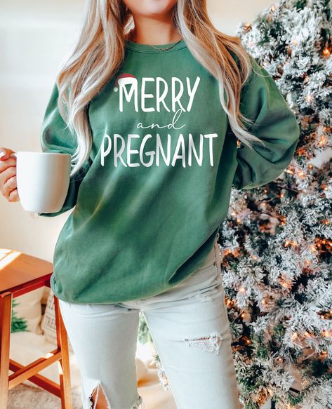 "Merry and Pregnant, Christmas Pregnant, Winter Baby Reveal, Holiday Pregnancy, Xmas Announcement, Comfort Colors®, Santa Sweatshirt WELCOME TO BUTIKCHI  This sweatshirt perfect gift as a holiday apparel. Ideal for any situation, a unisex heavy blend crewneck sweatshirt is pure comfort. How to Order?  Please, choose your favorite color and size from the pop-up window. Select the quantity that you want. Click \"ADD TO CART\". You can go back to add more product color for your loved ones members.  You can complete the checkout process. Please \"Click Proceed to Check Out\" Finally, you have completed all the steps, your product will be prepared to be shipped. Washing Care Instructors Use cold water when washing, do not use bleach, do not dry clean, and do not use an iron directly on the desi Very Merry And Pregnant, Merry And Pregnant, Pregnant Announcement Christmas, Cute Christmas Baby Announcements, Pregnancy Announcement Photoshoot Christmas, Christmas Baby 2 Announcement, Christmas Present Gender Reveal, 2nd Baby Announcement Christmas, Pregnancy Announcement Christmas Gift