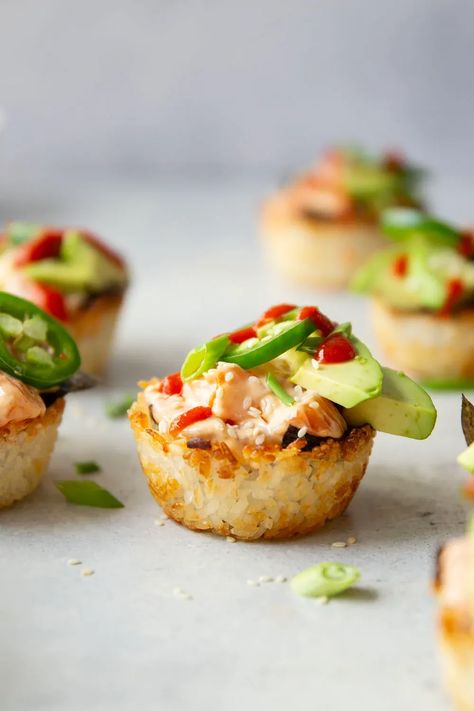 These spicy salmon sushi cups feature crispy rice cups filled with a sriracha salmon filling and topped with lots of fresh avocado and jalapeno. Salmon Sushi Cups, Sushi Cups, Rice Cups, Spicy Salmon Sushi, Sriracha Salmon, Salmon Appetizer, Crispy Salmon, Flaked Salmon, Sushi At Home