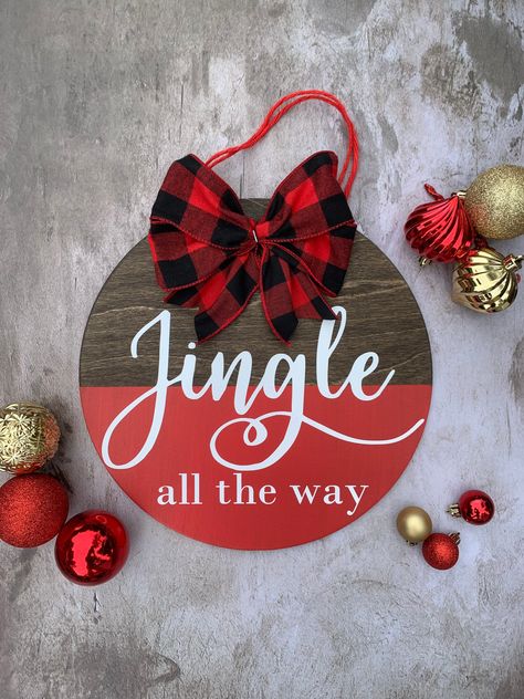 "🎄\"Jingle All The Way\" is sure to welcome all of your guests to your home this holiday season! 🎄12\" diameter round 🎄 1/4\" thick-- very light weight! 🎄jute string to hang 🎄adorable plaid bow decor 🎄perfect for the front door or any room of the house!" Round Cricut Door Signs, Christmas Door Hangers Not Round, Round Holiday Signs, Chrisrmas Door Hanger, Christmas Wreaths For Front Door How To Make, Christmas Decor Cricut, Cricut Round Wood Signs Diy Christmas, Christmas Wooden Door Hangers, Christmas Circle Wood Signs