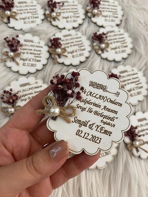 "\"Cherish your special day with our exquisite Wooden Wedding Magnet. Handmade and personalized, it makes a perfect guest gift. Adorned with dried flowers and pearls, this unique magnet is a timeless keepsake.\" Unveil lasting memories with our artisan-crafted Wooden Wedding Magnets--where every detail is a promise of personalized perfection. Why settle for ordinary wedding favors when you can enchant your guests with a timeless blend of nature and craftsmanship? *The wooden magnet is decorated with dried flowers and pearls. *The text can be changed upon request. *Dried flowers are available in natural colors such as pink or dark blue upon request. Charming, personalized, and a lasting reminder of your special day--this handmade wooden magnet with dried flowers and pearls makes for a uniqu Wedding Magnets, Flowers And Pearls, Unique Magnets, Personalized Wedding Decor, Magnet Collection, Wedding Magnet, Wooden Magnets, Wedding Gifts For Guests, Guest Gifts