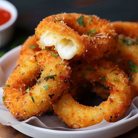 Embark on a culinary adventure with 'Crispy Delight: Mozzarella Stick Onion Rings,' where the beloved appetizer meets innovative cooking. This mouthwatering creation combines the gooey, stretchy joy of mozzarella sticks with the sweet, savory crunch of onion rings, resulting in a fusion snack that's sure to captivate and satisfy. Perfect for parties, game day gatherings, or as a novel treat for family movie nights, these mozzarella stick onion rings offer a fun and flavorful twist on classic ... Mozzarella Stick Onion Rings, Baked Mozzarella Onion Rings, Quick Savory Snacks Simple, Mozzarella Appetizers Appetizer Ideas, Mozzarella Cheese Sticks Recipe, Mozzarella Onion Rings, Giant Mozzarella Stick, Mozzarella Donut, Onion Rings Aesthetic