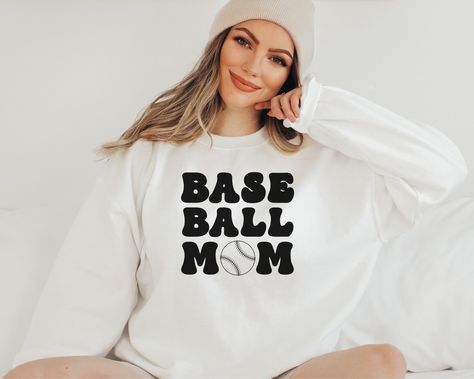 Are you looking for the perfect baseball mom sweatshirt for that baseball mama that you know? This cute baseball mom sweater is the perfect fit for every baseball game day or baseball tournament. Pick up this mama baseball sweatshirt today for yourself or as a gift! The sweatshirt is made from high-quality materials, so it's sure to keep you warm and comfortable all day long. PRODUCT DETAILS & PRINT --------------------- * Our sweatshirts is 50% cotton and 50% polyester. It's made of a soft and breathable material. * This sweatshirt is available in different sizes and colors; you can choose the desired option from the above drop-down menu. * Gildan Sweatshirts. * Unisex Adult Sizing. * Rolled Sleeves in pictures is for styling purposes only. * Props used in photos are NOT included with pur Game Day Cheer, Note Background, Basketball Mom Shirts, Basketball Sweatshirts, Cheer Svg, Baseball Mama, Mom Life Svg, Team Mom, Mom Hoodies