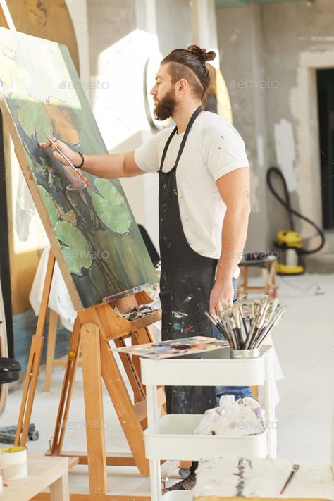 Bearded Male Artist Painting on Easel in Workshop by seventyfourimages. Vertical full length portrait of contemporary bearded artist painting picture on easel while working in art studio li... #Sponsored #seventyfourimages, #Workshop, #Vertical, #length Artist At Work Photography, Male Painter Photography, Painter Photography Artists, Male Artist Aesthetic, Art Workshop Ideas, Painter Pictures, Workshop Aesthetic, Artist Vibes, Side View Portrait