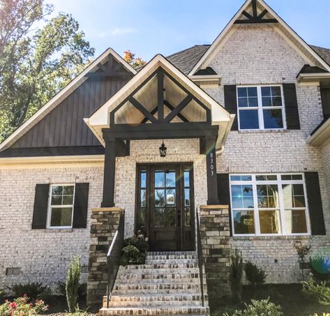 With a white brick like Villa Chase, dark trim, wood features and stone create solid and beautiful curb appeal. Ray Bullins Construction Parade entry. White Brick And Dark Siding Exterior, German Schmear Brick Exterior With Black Trim, White Brick House Brown Trim, Exterior House Brick Colors, Limestone House Black Trim, Black And White Brick House Exterior, Light Brick And Siding Exterior, Sofits And Facias Exterior, Light Brick Dark Trim House Exteriors