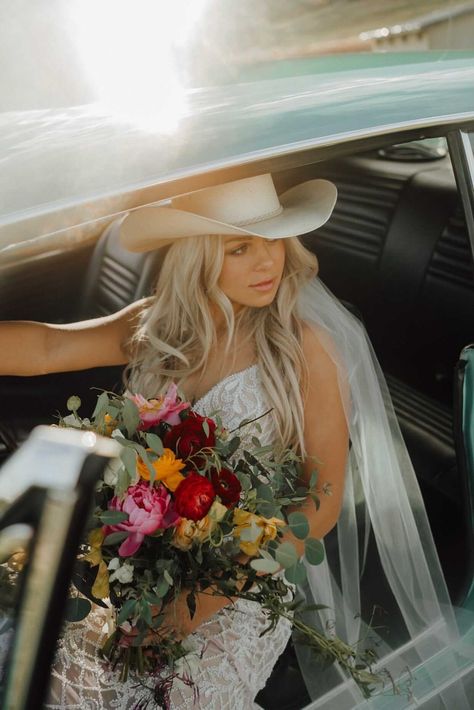 Stunning bride in cowgirl hat sitting in vintage car - Montana wedding inspiration - bride style Cowgirl Hat Wedding Dress, Wedding Cowgirl Hat For Bride, Cowboy Hat With Wedding Dress, Cowgirl Hat Veil, Bride With Cowboy Hat, Cowboy Beach Wedding, Cowgirl Wedding Hat, Wedding Hair With Cowboy Hat, Cowboy Hat Veil