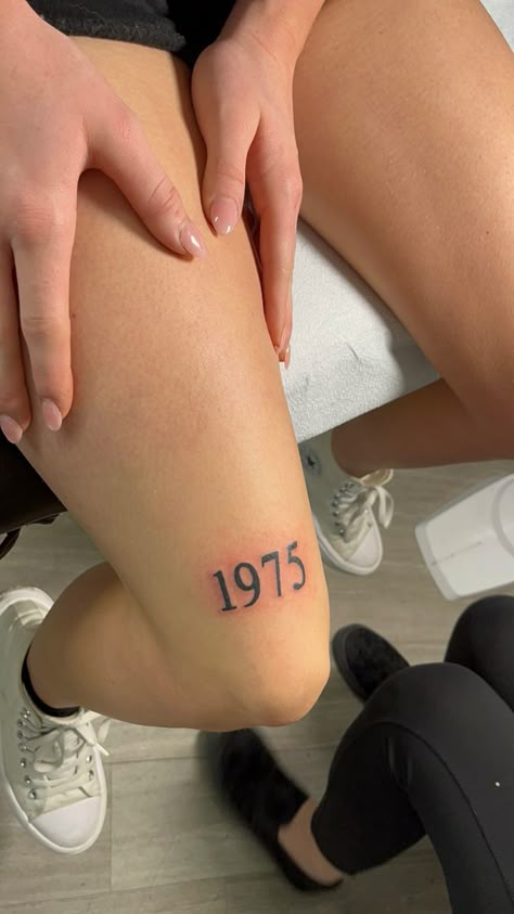 1975 tattoo above knee 2002 Knee Tattoo, Number Knee Tattoo, Tattoo Ideas Knee Female, Year Above Knee Tattoo, Tattoo Ideas Female Knee, Knee Tattoo Words, Thigh Tattoo Simple, 2006 Tattoo, 1975 Tattoo