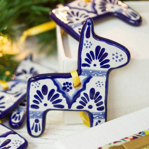 In blue on white, four burros, or donkeys, are painted by hand with intricate motifs. Mexican artisan Pedro Tecayehuatl designs this set of four ornaments, which he crafts from ceramic in the style of Talavera handicrafts. Talavera Art, Mexican Christmas Decorations, Dia De Los Muertos Decorations Ideas, Mexico Gift, Mexican Christmas, Mexican Ceramics, Classroom Art Projects, Mexican Home Decor, Mexican Crafts