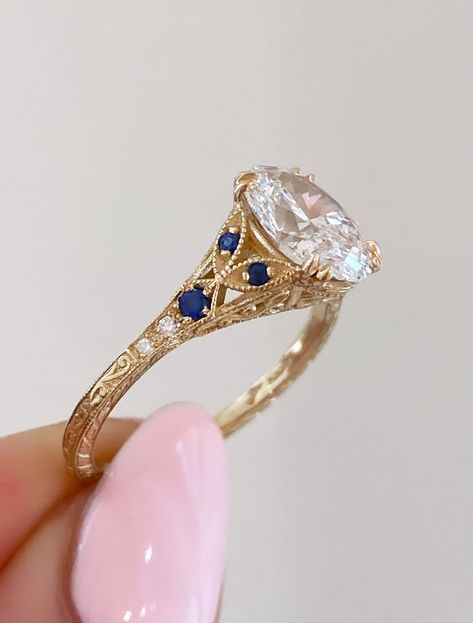 Skyla - Sapphire is a timeless masterpiece that captures the essence of romance and elegance. Its enchanting silhouette features delicate curves and ornate embellishments with three vibrant blue sapphires are set on either side of her oval heart for a regal pop of color. Islet's curved band holds a marquise diamond as the center piece accompanied by two baguette cuts on either side with round cut sparklers finishing off the piece. Natali - Curved completes the stack with a gentle hug of diamonds