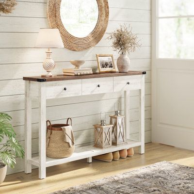 Transform your space with this exquisite console table that exudes farmhouse charm with its wood-effect finish, sleek lines, and elegant metal accents. Featuring 1 tabletop, 3 drawers, and 1 open shelf, this entry table ensures your belongings are neatly stored. Constructed of particleboard, solid wood, and MDF panels, this narrow entryway table can support up to 110 lb on the tabletop and 22 lb in each drawer. Whether in the hallway, living room, bedroom, or study, this console table offers a perfect blend of style and functionality. Winston Porter Table Base Color: White | Winston Porter Sahai 47.2" Console Table w / 3 Drawers 30.0 H x 47.2 W x 9.4 D in / brownWood in White | 30" H X 47.2" W X 9.4" D | Wayfair White Washed Entry Table, Entryway Decor For Small Space, Foyer Table And Mirror, Sage Green Entry Table, Entry Way Table Decor Boho, Narrow Entryway Table Decor, Front Entryway Table Decor, Hallway Credenza, Coastal Entry Table