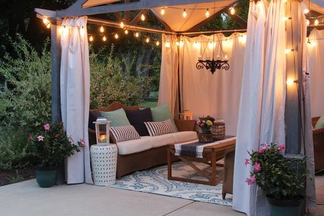 Pergola with edison bulb lights, canvas curtains and cozy seating at dusk Canvas Curtains, Diy Bamboo, Blue Interiors, Pergola Curtains, Farmhouse Patio, Cheap Pergola, Pergola Lighting, Pergola Attached To House, Pergola Design