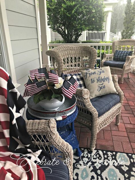 A Patriotic Porch Tour - Celebrate & Decorate Patriotic Porch, Old Wicker, Memorial Day Decorations, Yellow Brick Home, Red Geraniums, Decorative Bird Houses, Wicker Table, Brick Home, Front Porch Decorating