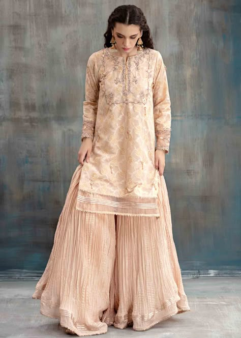 Include: Shirt Gharara Dupatta Fabric: Cotton organza Color: Peach Work Technique: Embroidered Description: This peach straight self printed cotton with organza border patches with gota, sitara, nakshi, stones and gems detailed embroidory is a must-have! Inctricate detailing on the sleeve cuffs. Crushed traditional gharara with gota kinari lacing. Comes with mokesh detaling dupatta. A perfect blend of traditional and modern! This is a 3 Piece stitched outfit. Disclaimer: The color of the outfit Traditional Gharara, Gharara Designs, Frocks And Gowns, Pakistan Dress, Stylish Kurtis Design, Lace Suit, Mother Of Bride Outfits, Celebrity Fashion Looks, Casual Party Dresses