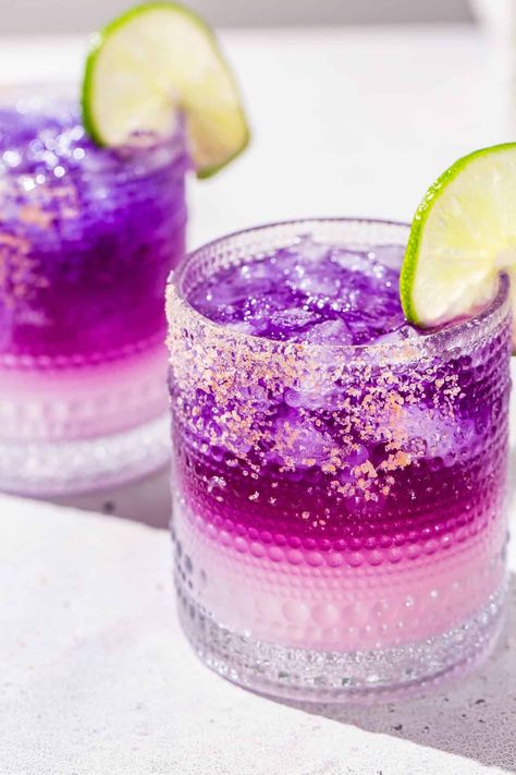 The Galaxy Margarita is as tasty as it is beautiful! Tequila that's naturally colored by butterfly pea flowers is layered on top of a Cointreau and lime base. Edible glitter takes it to the next level! It is a fun galactic spin on a classic margarita. This is the perfect margarita recipe for a girls night, bachelorette or just a night of stargazing! Purple Margarita, Margarita Flight, Glitter Cocktails, Perfect Margarita Recipe, Tequila Drinks Recipes, The Perfect Margarita, Butterfly Pea Flowers, Perfect Margarita, Tacos And Tequila