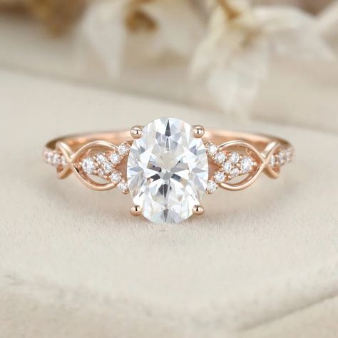 This stunning 1.5ct oval-shaped Moissanite engagement ring is a unique vintage piece that is sure to turn heads. Crafted in rose gold, the twist wedding ring design adds a touch of elegance and sophistication. Engagement Rings Rose Gold Band, Classy Engagement Ring Vintage, Oval Engagement Ring Settings, Oval Engagement Ring Rose Gold, Twist Wedding Ring, Sparkly Rings, Wedding And Engagement Ring, Rose Gold Engagement Rings, Halo Moissanite Engagement Ring