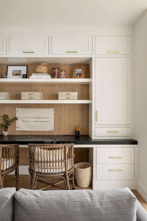 Family room features a black marble top built in desk with brown bamboo chairs under shelves surrounded by white cabinets with brass pulls, Mix Wood Tones, Kids Homework Room, Hilltop Estate, Homework Room, Office Nook, Design A Space, Wood Tones, How To Mix, Built In Desk