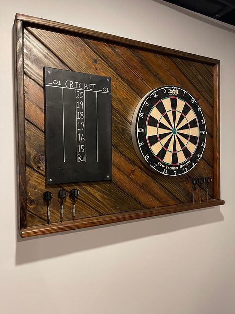 A great addition to your Game Room, Garage, Patio or Man Cave, this Dart Backboard is 39.75 X 30H.  It is custom made in a variety of stains and adds style and decor to your game. Hanging hardware included. **Optional Score Board** **Backboard has pre drilled holes for darts** Dart Board and darts not included Dimensions 40W x 30H x 4D RETURNS: Are welcome for this product but the buyer must pay for any shipping cost that occur in this transaction. Dart Backboard, Dart Board Backboard, Darts Board, Room Ideas Men, Dart Board Wall, Small Man Cave, Board Game Room, Garage Game Rooms, Small Game Rooms