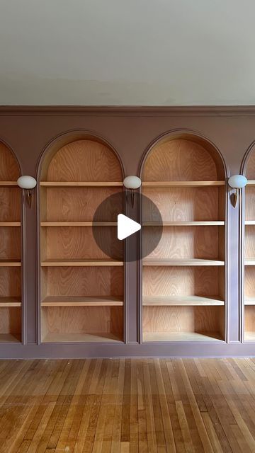 Jourdan Fairchild on Instagram: "Meet our latest—and dare I say greatest—design project to date: a wall of custom arched bookshelves with stained wood interiors and vintage Italian lighting.✨  What started from my sketch on paper in May of last year, my husband Andrew drew directly on the wall with a pencil and then weekend by weekend over 10(!) months built into the grandest focal point in our living room. And he really, truly outdid himself with the level of detail at every seam. I’m honestly blown away by his master-level craftsmanship.   They’re unlike anything I’ve seen elsewhere, make the ceilings feel even higher, and just *feel* right for us and this old home. They’ll certainly make us love where we live a bit more.💕" Antique Built In Bookcase, Vintage Wall Bookshelf, Custom Bookcases Built Ins, Arched Library Wall, Arched Shelf Built In, Arched Built In Bookcase, Arch Bookshelves, Built In Arched Bookshelves, Build In Shelves Living Room