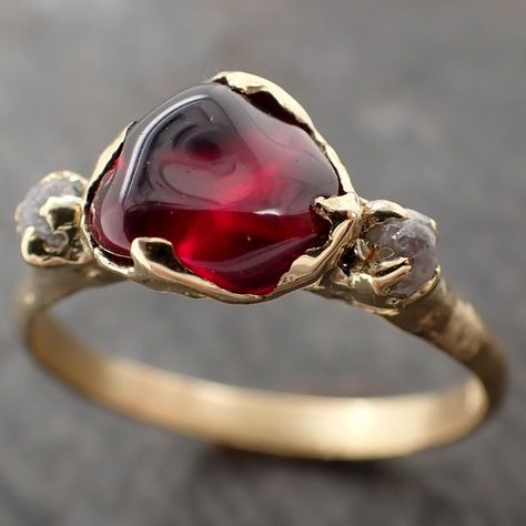 Raw rough color change Garnet with raw conflict-free diamonds on each side. I hand carved this ring in wax and cast it in recycled solid Yellow 18k gold using the lost wax casting process. This one of a kind raw gemstone ring is a size 7 it can be resized up or down. The Garnet measures about 6.5mm x 7.5mm. The rough diamonds are about 2mm. Throughout all time and history in every tribe and culture all around the world crystals, minerals and gemstones have used for healing, luck, divination, ado Engagement Rings Raw Stone, Raw Ruby Ring, Raw Stone Engagement Rings, 18k Gold Engagement Ring, Garnet Wedding Rings, Stone Wedding Ring, Garnet Wedding, Garnet And Diamond Ring, Big Stone Ring