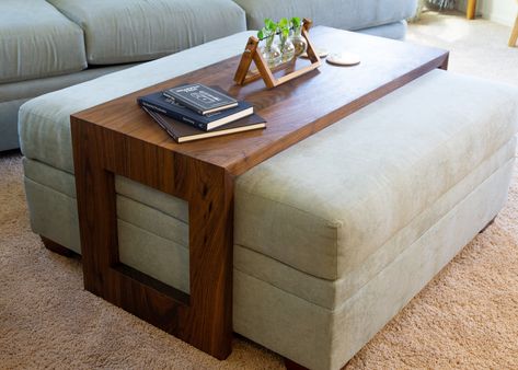 Introducing the "Ansley" a bespoke ottoman table that beautifully blends modern design with timeless appeal. Crafted from your choice of Walnut, Cherry, or White Oak, each piece starts with carefully hand-selected boards for the top, ensuring unmatched quality and a cohesive aesthetic. The table's standout feature, a waterfall edge with mitered corners, allows the grain to flow seamlessly around the piece, complemented by a subtle 10-degree relief on the inside edges, adding depth and sophistica Ottoman With Side Table, Ottoman With Wood Overlay, Sectional With Ottoman And Coffee Table, Ottoman As Coffee Table Living Rooms, L Couch Coffee Table, Bench Coffee Table Ideas, Waterfall Ottoman Table, Coffee Table For U Shaped Sectional, Ottoman Waterfall Table