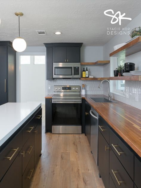 Black Cabinets, butcher block counters, quartz waterfall counter on island, open shelving || Designed by Stacie Kop Designs #kitchendesign #kitchenideas #kitchen #midmodkitchen Butcher Block And Granite Countertops Together, Kitchen With Butcher Block And Quartz, Butcher Block Countertops Quartz Island, Butcher Block Countertops With Quartz Island, Butcher Block And Quartz Countertops Kitchen, Black Cabinet With Butcher Block, Dark Cabinets And Butcher Block, Modern Farmhouse Black Kitchen Cabinets, Black Cabinets Butcher Block Countertops