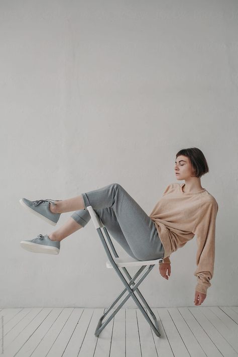 Portrait of young woman in stylish urban clothes sitting and posing on the chair Model Posing Guide, Indoor Photography Poses, Pose Sitting, Sitting Pose Reference, Chair Photography, Chair Pose, Female Pose Reference, Body Reference Poses, Sitting Poses