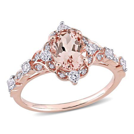 This intricately designed Miabella Vintage Halo Ring is the epitome of beauty and grace. Crafted in lustrous rose gold, this sophisticated ring features an oval-cut prong-set morganite gemstone (8x6mm) encased in a beautiful halo design created by eight round-cut prong-set white sapphire gemstones (2.25x2.25mm)(2x2mm) and 16 round-cut pave-set diamonds (G-H, I1-I2). Enhanced with a polished finish, this classic ring is perfect for a quick glam fix. This classic and sparkling piece is indeed a ti Rose Gold Halo Ring, Vintage Halo Ring, Rose Gold Oval Engagement Ring, Verragio Engagement Rings, Pretty Engagement Rings, Vintage Halo, Rose Gold Halo, Cute Engagement Rings, Future Engagement Rings