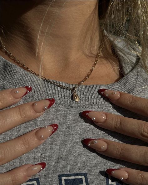 Red Almond Nails With Pearls, Red French Tip Nails Almond With Pearls, Red Pearly Nails, Pearl Nails With French Tip, Maroon Nails With Rhinestones, Red French Tips With Pearls, Red French Tip Nails With Diamonds, Red French Tips With Gems, Red French Tip Nails With Gems