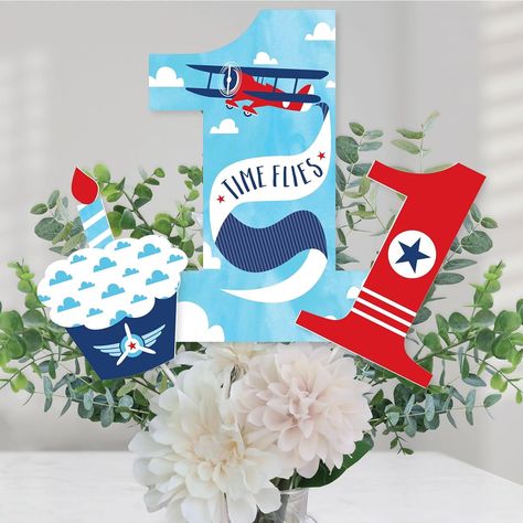 1st Birthday Taking Flight - Plane Centerpiece Sticks includes 15 1st Birthday Taking Flight - Plane table toppers in 3 different shapes, wooden sticks and easy to assemble stickers. Vintage 1st birthday party table decorations are perfect for any first birthday party. Taking Flight - Plane 1st Birthday Centerpiece Sticks Size 5 Numbers 1 Table Topper 7.75"W x 10.75"H 5 Cupcake Table Toppers 5"W x 7"H 5 Table Toppers 4.75"W x 7"H With their unique design and variety of pieces, this table decoration kit will be a striking addition to any red plane first birthday party. EASY PARTY DECORATIONS: 1st Birthday Taking Flight - Plane table decor can be used as a centerpiece when attached to the included dowels and inserted into a vase or floral arrangement. Add them to apothecary jars to easily ac Plane Centerpiece, 1st Birthday Centerpieces, Birthday Party Table Decorations, Second Birthday Party, Easy Party Decorations, Airplane Birthday Party, Birthday Table Decorations, Candy Birthday Party, Birthday Party Centerpieces