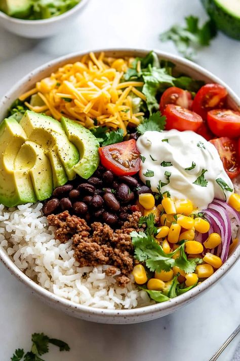 This ground beef burrito bowl is hearty, satisfying, and so delicious! It's loaded with beef, beans, corn, lettuce, tomatoes, cheese, and a tangy sauce atop cilantro lime rice. Ground Beef Bowl Mexican, Chipotle Beef Burrito Bowl, Healthy Ground Beef Taco Bowls, Ground Beef Chipotle Bowl, Buddha Bowl With Meat, Hamburger Burrito Bowl, Meat Bowl Recipes, Ground Beef Veggie Bowl, Crazy Bowls And Wraps Recipes