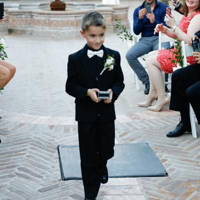 Ring bearer walks down the aisle in cute all black tux and precious cargo | One Fine Day Photography | villasiena.cc Ring Bearer All Black Outfit, All Black Ring Bearer Outfit, Ring Bearer Outfit Black, Black Ring Bearer, All Black Tux, Ring Bear, Bearer Outfit, Ring Bearer Outfit, Day Photography