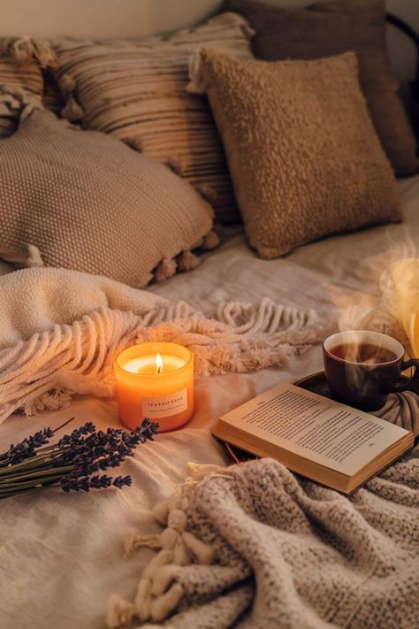 A lit candle, a book, and a cup of tea on a bed with a cozy blanket. Perfect for a relaxing evening. Book And Tea, Tea Candles, Cozy Night, Book Candle, Cozy Reading, Cozy Living Rooms, Cup Of Tea, Knitted Blankets, Night In