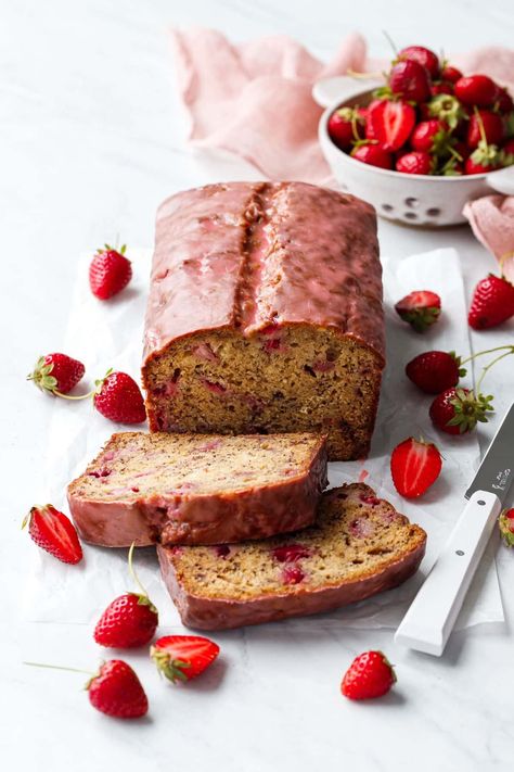 Loaf of Strawberry Banana Bread with a pink glaze, two slices laying down to show the interior texture, and strainer with strawberries in the background. Strawberry Loaf, Buns Homemade, Strawberry Roll Cake, Strawberry Banana Bread, Best Comfort Food Recipes, Strawberry Glaze, Buns Recipe, Mexico Food, Strawberry Syrup