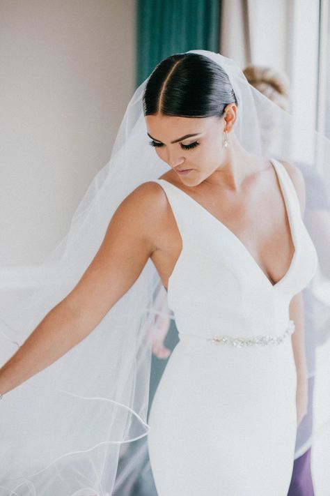 bride-in-v-neck-wedding-dress-jewel-belt-sash-middle-part-sleek-coiffure-low-bun-pretty-makeup-lash Bridal Headband With Hair Up, Wedding Hair Down Middle Part, Jewel Belt, Low Bun Wedding Hair, Cartagena Wedding, Morning Bun, Jeweled Wedding Dress, White Boutique, Wedding Bun