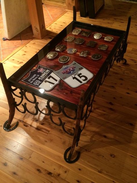 Display coffee table; horseshoes, harness hames, and cedar GAW-JUSSSSSX Homemade Display Case, Trophy Saddle Display, Belt Buckle Display Coffee Table, Rodeo Back Number Display, Horseshoe Furniture, Western Ranch Home Decor, Shipping Container Shop, Saddle Room, Rodeo Awards