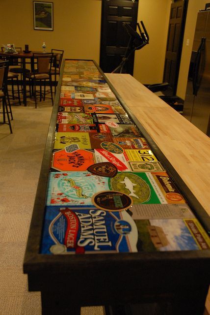 Bar Top. (Six pack cartons and beer memorabilia with layer of epoxy.) Epoxy Bar Top Ideas, Beer Ideas, Beer Top, Beer Memorabilia, Bar Tops, Pub Sheds, Bar Beer, Man Cave Basement, Military Patches