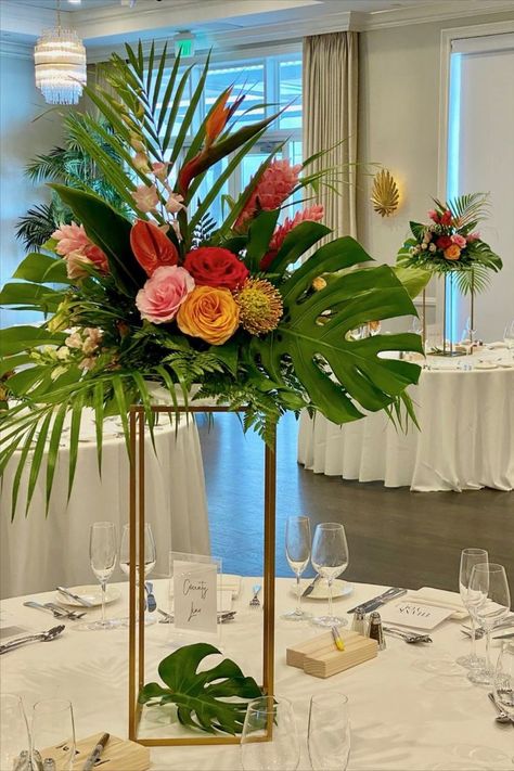 Tall Tropical Centerpiece on gold stand Tropical Wedding Gazebo Decor, Palm Frond Decor Wedding, Hawaiian Flower Centerpieces, Tropical Arrangements Centerpieces, Tall Tropical Centerpieces Wedding, Tropical Lantern Centerpieces, Birds Of Paradise Centerpiece, Diy Tropical Centerpieces Wedding, Wedding Palm Leaves