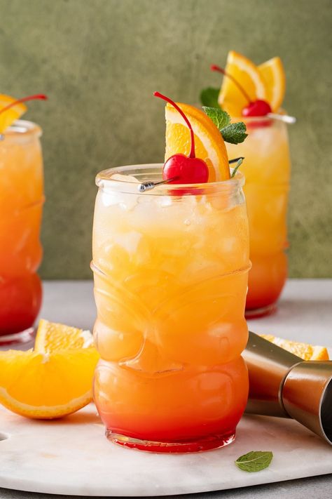 Try this rum punch for a truly tropical treat! It's a delicious blend of lime, pineapple, orange juice, and rum. No one can resist it! Run Punch Recipe, Country Cocktails, Tropical Rum Punch, Rum Punch Cocktail, Rum Punch Recipe, Rum Drinks Recipes, Rum Punch Recipes, Trinidad Recipes, Spicy Cocktail