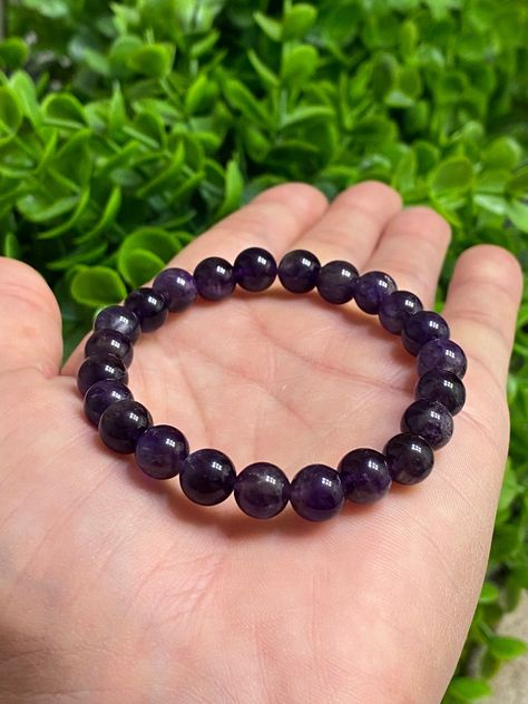 "This piece is a unisex stretch bracelet. It is handcrafted and double strung with clear Magic Stretch Cord for extra durability. Made with beautiful 8mm Natural Dark Purple Amethyst beads.  A bracelet of 6.5-7 inches is the most common in women's jewelry. Keep in mind that they will stretch over the wrist and so should fit a range of wrist sizes up to about 8 inches A bracelet of 7.5-8 inches is the most common in men's bracelets. Keep in mind that they will stretch over the wrist and so should Zodiac Stones, Men's Bracelets, Glass Bracelet, Amethyst Bracelet, Amethyst Beads, Photo Bracelet, Gemstone Bracelets, Women's Jewelry, Purple Amethyst