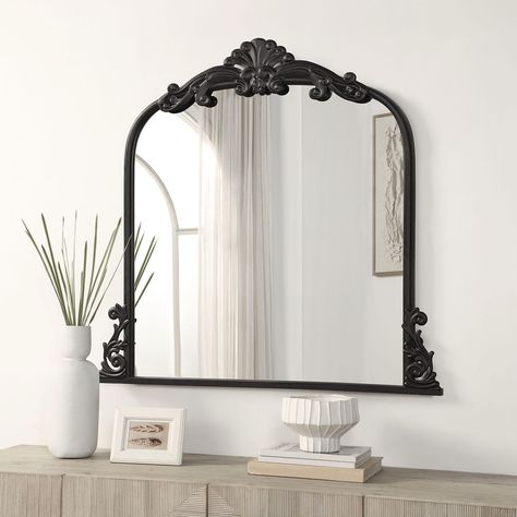 The Azalea Park Filigree Wall Mirror will add elegance to any room. This product features a glass mirror and a frame which is made from iron and built to last. The frame has luxurious details around the border with two filigree motifs on the sides of the product with one center piece on the top. The mirror comes in two finishes: an antique gold or matte black.This vintage inspired product is perfect for above a console table, mantel or dresser. It’s also a great option for a vanity mirror to cre Mirrors Over Fireplace Mantle, Mantle Mirror Decor, Above Nightstand Decor, Foyer Mirror Ideas Entry Ways, Fireplace Mirror Ideas, Mirror Over Fireplace, Black Frame Mirror, Nursery Mirror, Foyer Mirror