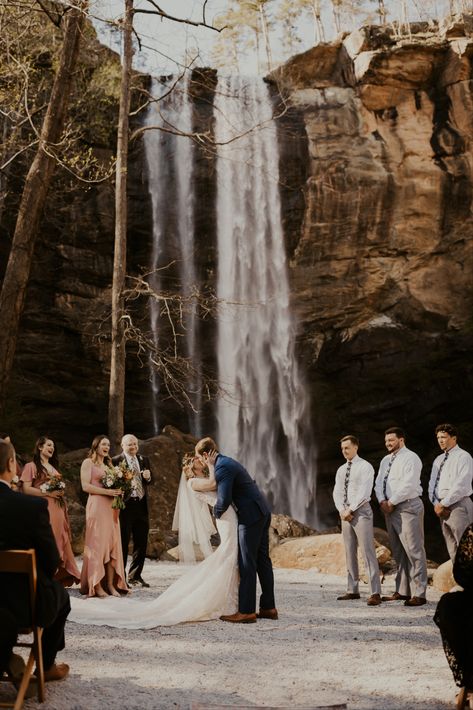 Bride and Groom share their first kiss in front of Toccoa Falls in Georgia. Wedding Venues Waterfall, Wedding At Waterfall, Toccoa Falls Georgia Wedding, Overlook Wedding Ceremony, Tocca Falls Georgia Wedding, Intimate Wedding Locations, Water Fall Wedding Ideas, Fall Wedding Locations, Waterfall Wedding Ceremony