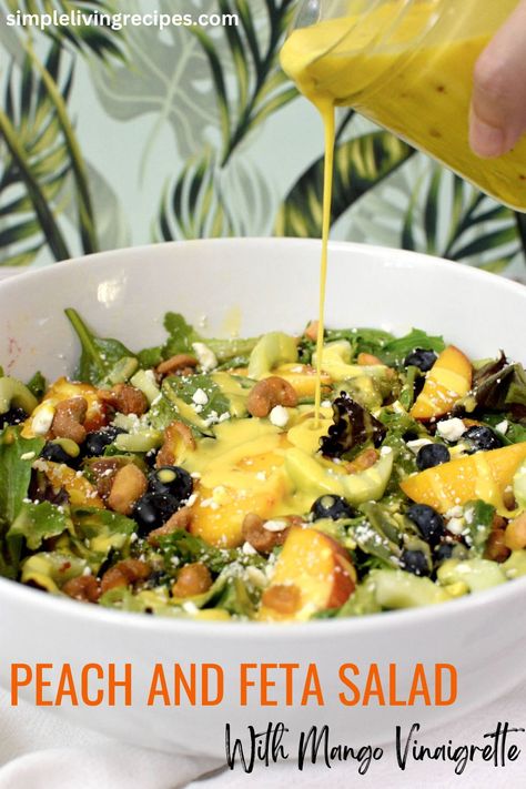 Spring mix salad in a bowl with peaches, blueberries, cucumber, cashews, and feta cheese, being drizzled with mango vinaigrette. Mango Vinaigrette Dressing Recipe, Sweet Cashews, Mango Vinaigrette Dressing, Peach Feta Salad, Mango Vinaigrette, Light Salad Recipes, Mango Salad Dressing, Salad With Blueberries, Mango Dressing